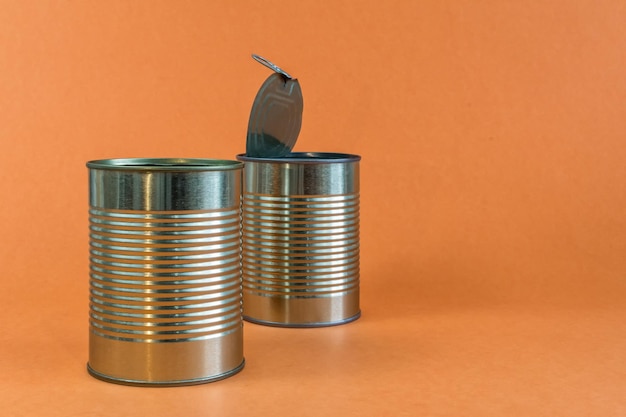 Empty metal cans and tins on an orange background Recycling concept and environment