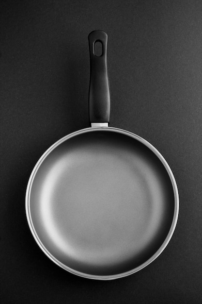 Empty metal frying pan on the dark.