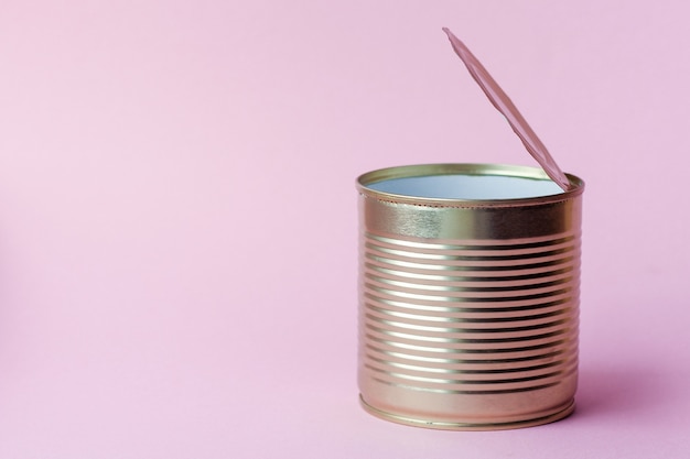 empty metal tin can on a pink background. concept of waste and garbage sorting