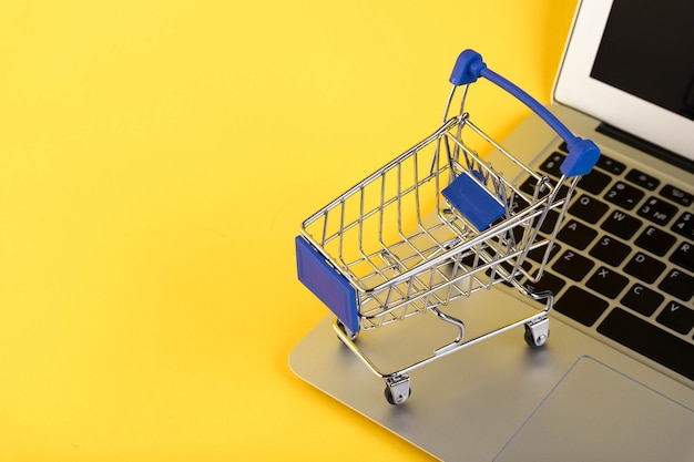 Empty mini shopping trolley, Shopping cart, on a yellow 