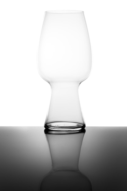 Empty modern beer glass and reflection isolated on white