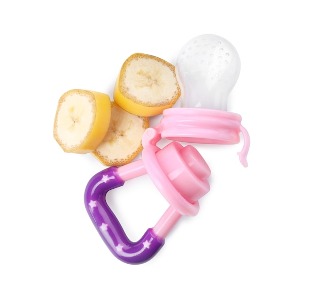 Empty nibbler and cut banana on white background top view Baby feeder