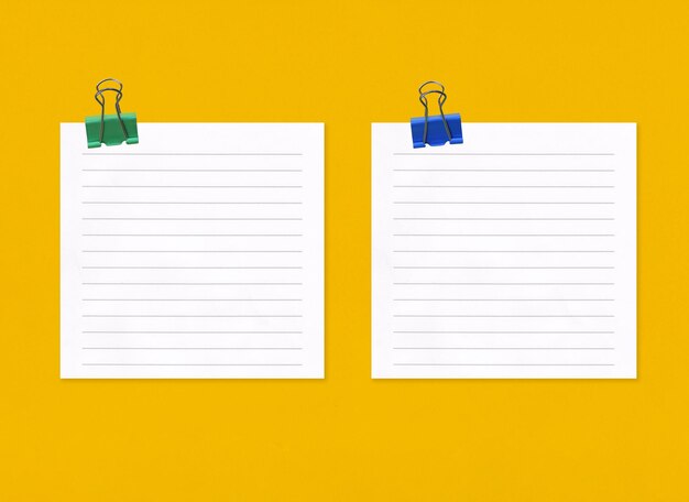 Empty note paper with clip on yellow art paper background and have copy space for your design