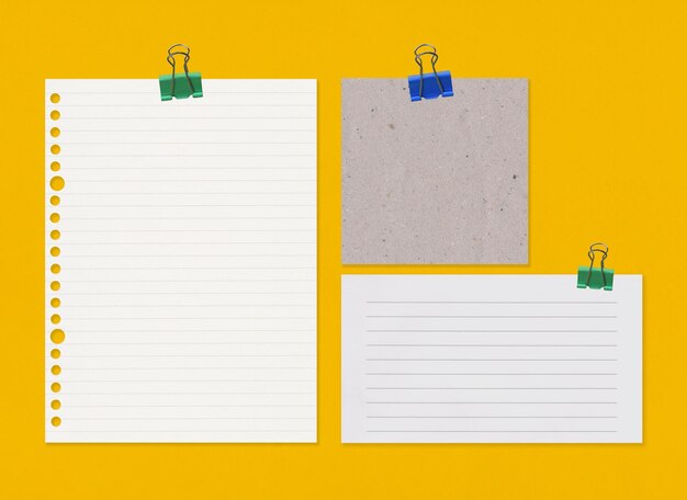 Empty note paper with clip on yellow art paper background and have copy space for your design