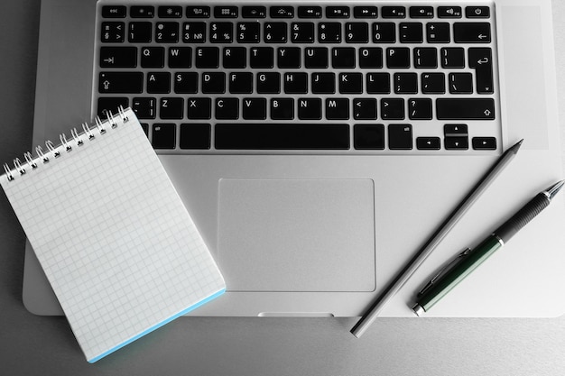 Empty notebook on laptop keyboard on light background