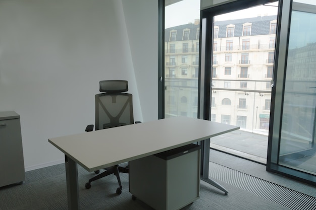 Foto ufficio vuoto con tavolo e sedia posto di lavoro