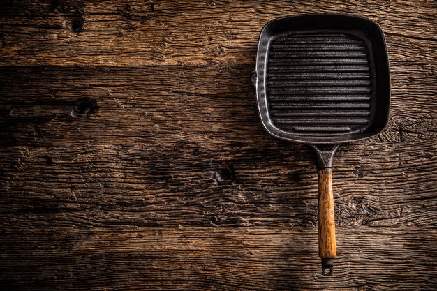 Photo empty old grill pan on rustic oak table top of view