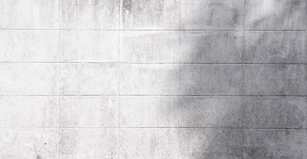 Фото Пустая старая белая кирпичная стена, сделанная из блоков для абстрактного фона и текстуры на солнечном свете, красивые узоры, плоский фон, фотопространство для работы крупным планом