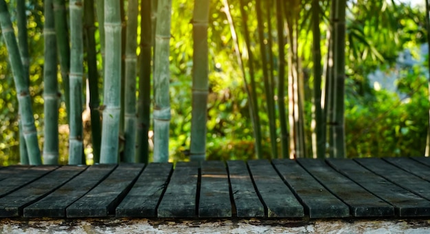 写真 製品モンタージュの自然な竹林の背景を持つ空の古い木の板水平