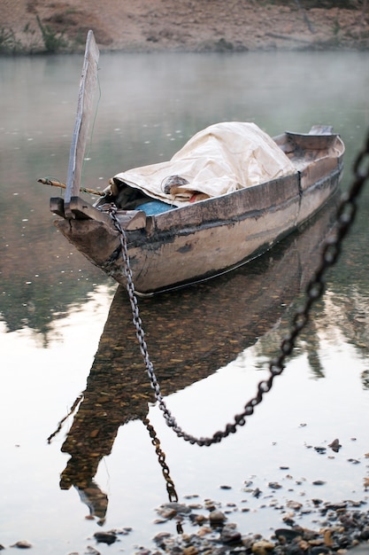 Empty old wooden boat on the waves close up