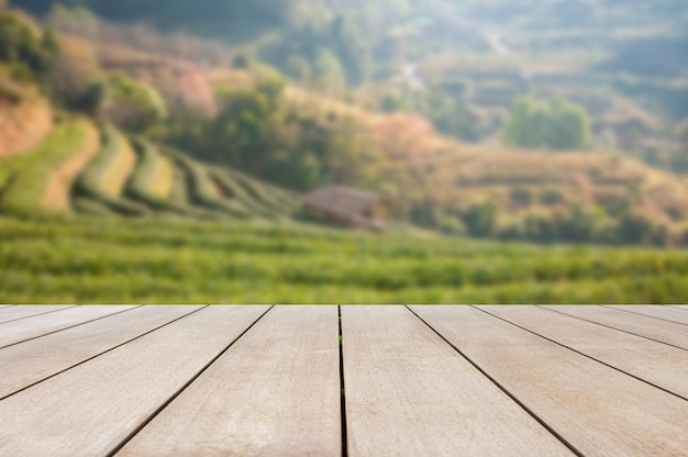 Empty old wooden table in front of blurred beautiful tea plantation view and mountain with beautiful sunrise background of nature Can be used for display or montage for show your products