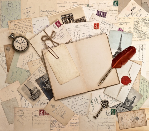 Empty open book, old accessories and post cards. sentimental vintage background