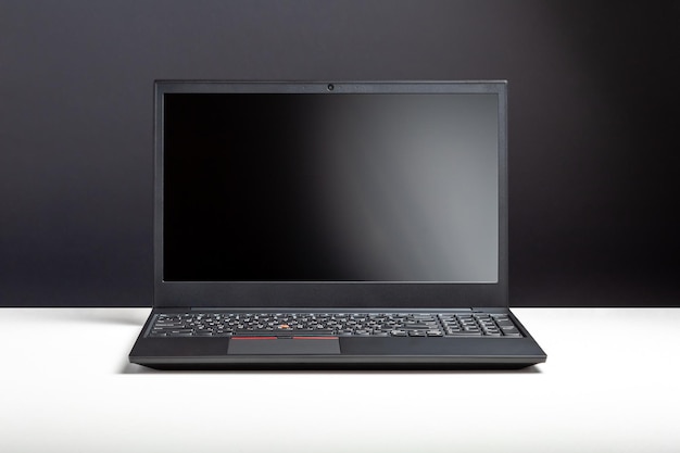 Photo empty open laptop with mockup on white desk table with black screen. minimalist work space with modern notebook. personal laptop screen template for website digital design.