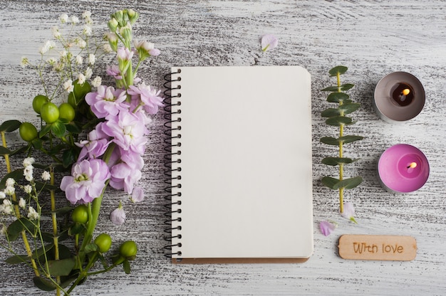 Empty open notepad with flowers and candles