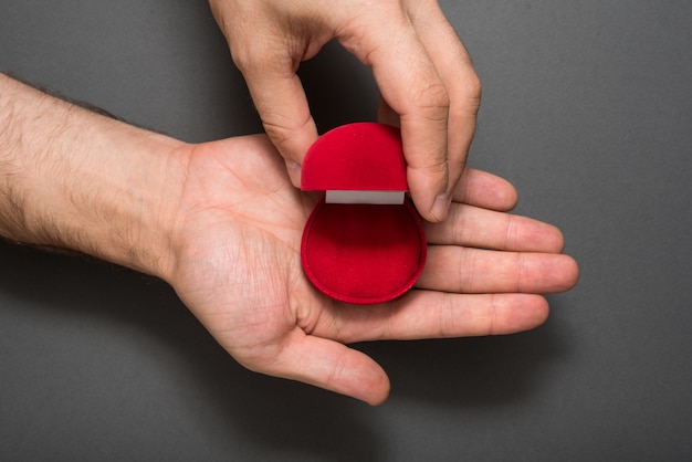 Empty open red jewelry box in a male hands