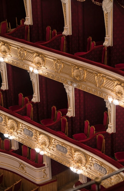 Пустые уровни балкона оперного театра с красными стульями