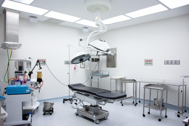 empty operating room with wheeled tables and one stretcher