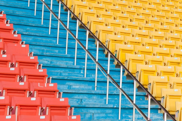 경기장의 빈 주황색 및 노란색 좌석축구 경기장 좌석