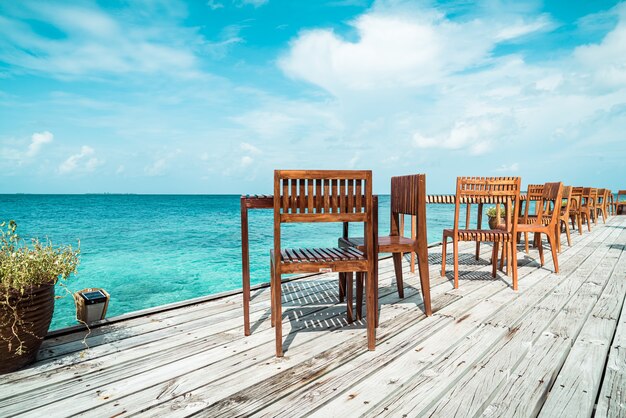 empty outdoor wood table and chair with sea view background in Maldives