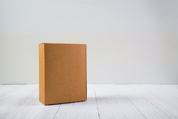 Photo empty package brown cardboard box or tray on bright wooden table with copy space.