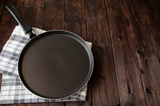 an empty pancake pan on a white checkered kitchen towel