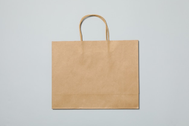 Empty paper bag on gray background, space for text