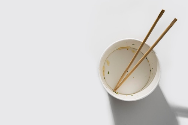흰색 배경에 중국 막대기가 있는 빈 종이 그릇상단 보기 플레이 레이