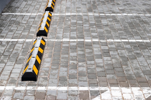 An empty parking lot in a residential area with yellow parking stops for cars closeup Stop Parking Limiter