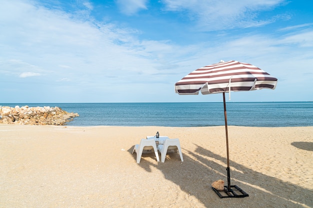 海のビーチの背景を持つビーチの空のパティオ屋外テーブルと椅子