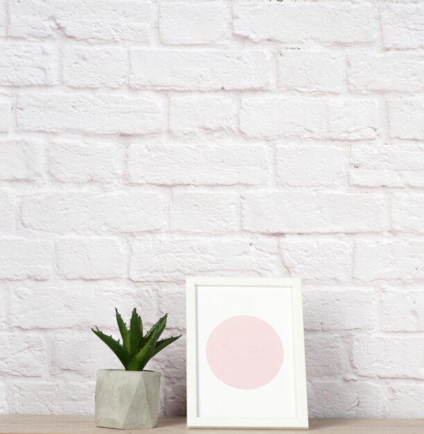 Photo empty photo frame aloe in a white ceramic pot white brick wall