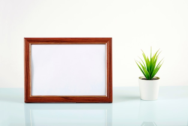 Empty photo frame and flower on the mirror table.