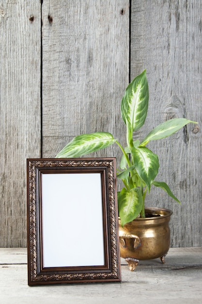 Empty picture frame on wooden background.