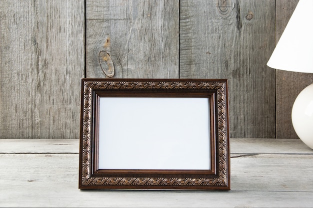 Empty picture frame on wooden background.