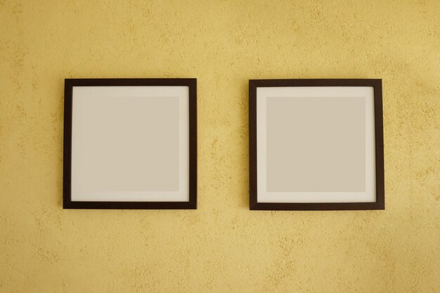 Empty picture frames on vintage yellow walls.