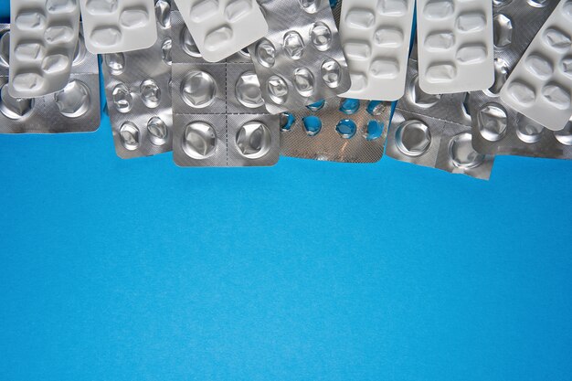 Empty pills blister on blue background. health care and medicine background