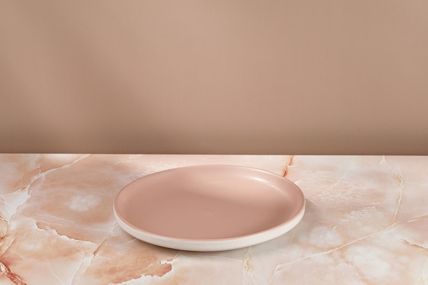 Empty pink blank plate on beige pink marble background\
minimalist mock up for product presentation