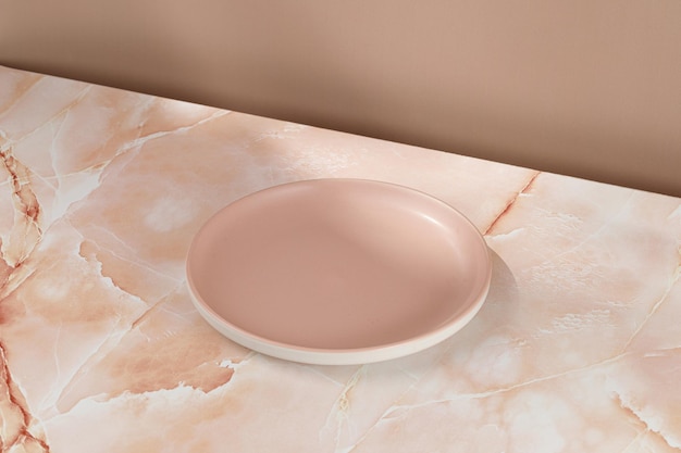베이지색 분홍색 대리석 배경의 빈 분홍색 빈 접시 미니멀리스트는 제품 프레젠테이션을 위해 조롱합니다.