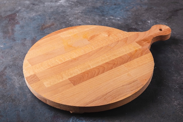 Empty pizza board isolated a dark surface