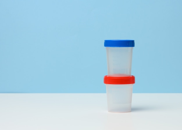 Empty plastic container for the collection of analyzes on a white table, blue background