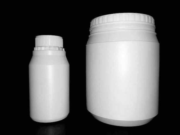 Empty plastic white bottles on a dark background.