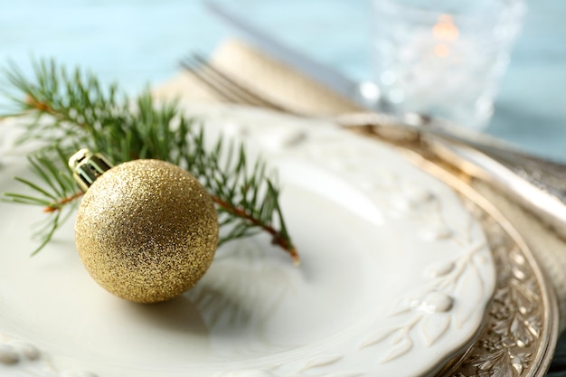 Empty plate, cutlery, napkin and glass on rustic wooden background. Christmas table setting concept