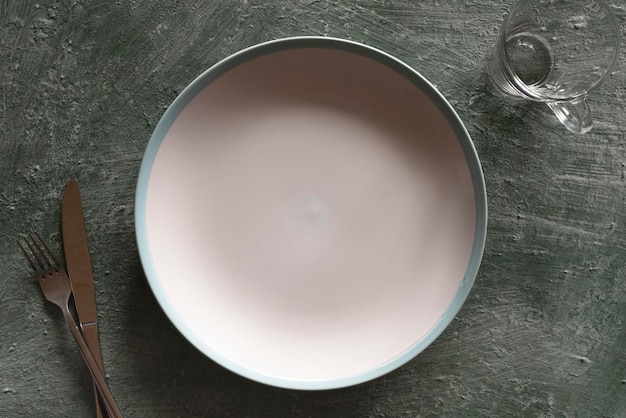 Empty plate and cutlery on stone green background