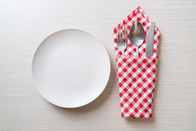 empty plate or dish with knife, fork and spoon on wood tile background