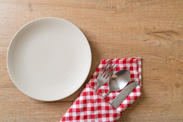 empty plate or dish with knife, fork and spoon on wooden board