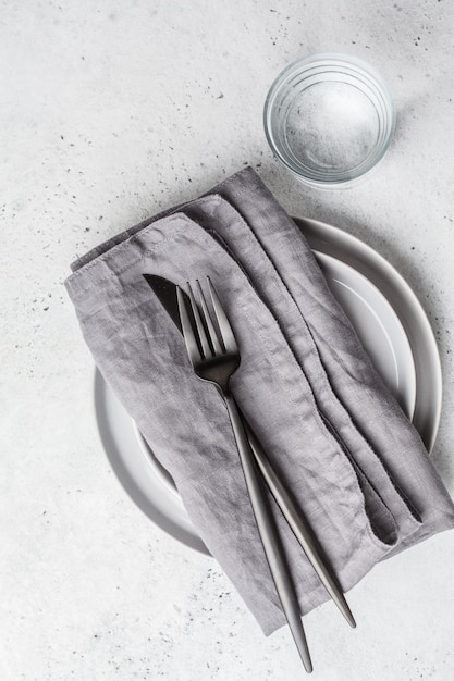 Empty plate and glass of water, white background, top view. Medical fasting concept.