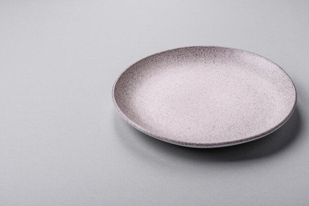 Photo an empty plate on a gray concrete background with copy space