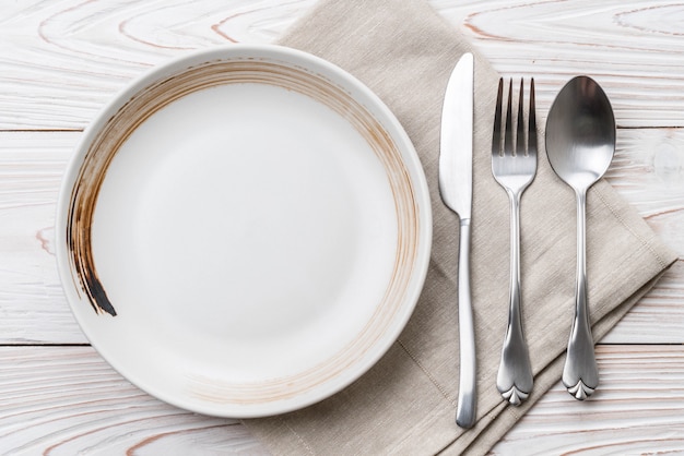 empty plate spoon fork and knife