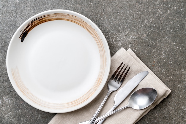 empty plate spoon fork and knife