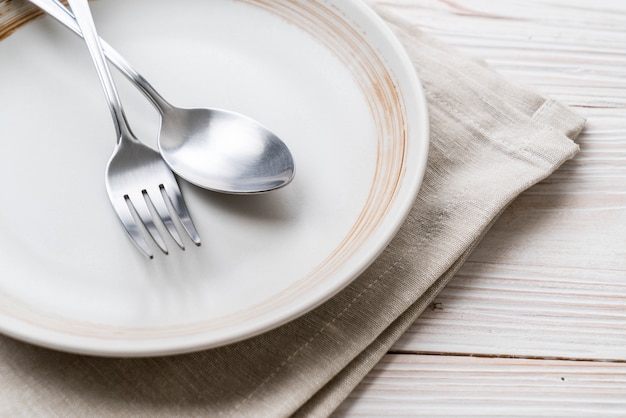 empty plate spoon fork and knife