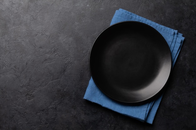 Empty plate and towel on stone table